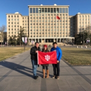 IU Alumni (L-R) Jon Kay, Carrie Hertz, and Peter Yen (IUPUI Recruitment Coordinator and Assistant Office Manager at the China Gateway) pose with the IU Flag on the campus of IU partner Tsinghua University in Beijing. December 8, 2017. Photograph by Jason Jackson.