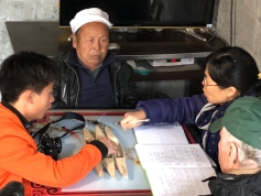 After finishing his rice basket, Mr. Li Guicai (C) gave an interview to Zhang Lijun and Kurt Dewhurst (R) and Lu Chaoming (L). December 15, 2017. Photograph by Jason Baird Jackson.